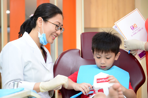 Bác sĩ trò chuyện với bé về việc chăm sóc răng miệng.